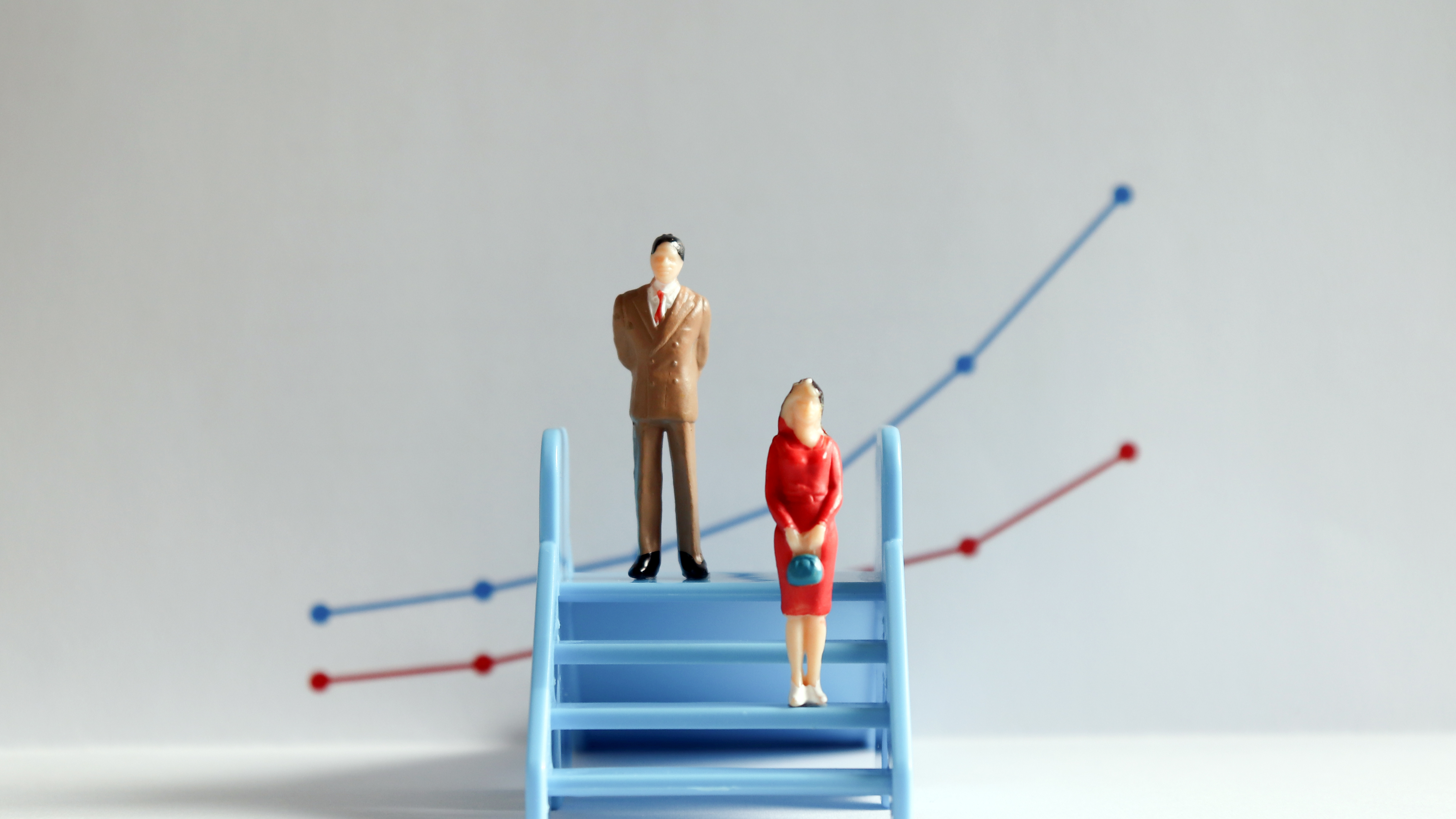 The concept of gender pay gap. A miniature man and a miniature w
