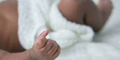 Awake Newborn Baby hands on Cream White Background